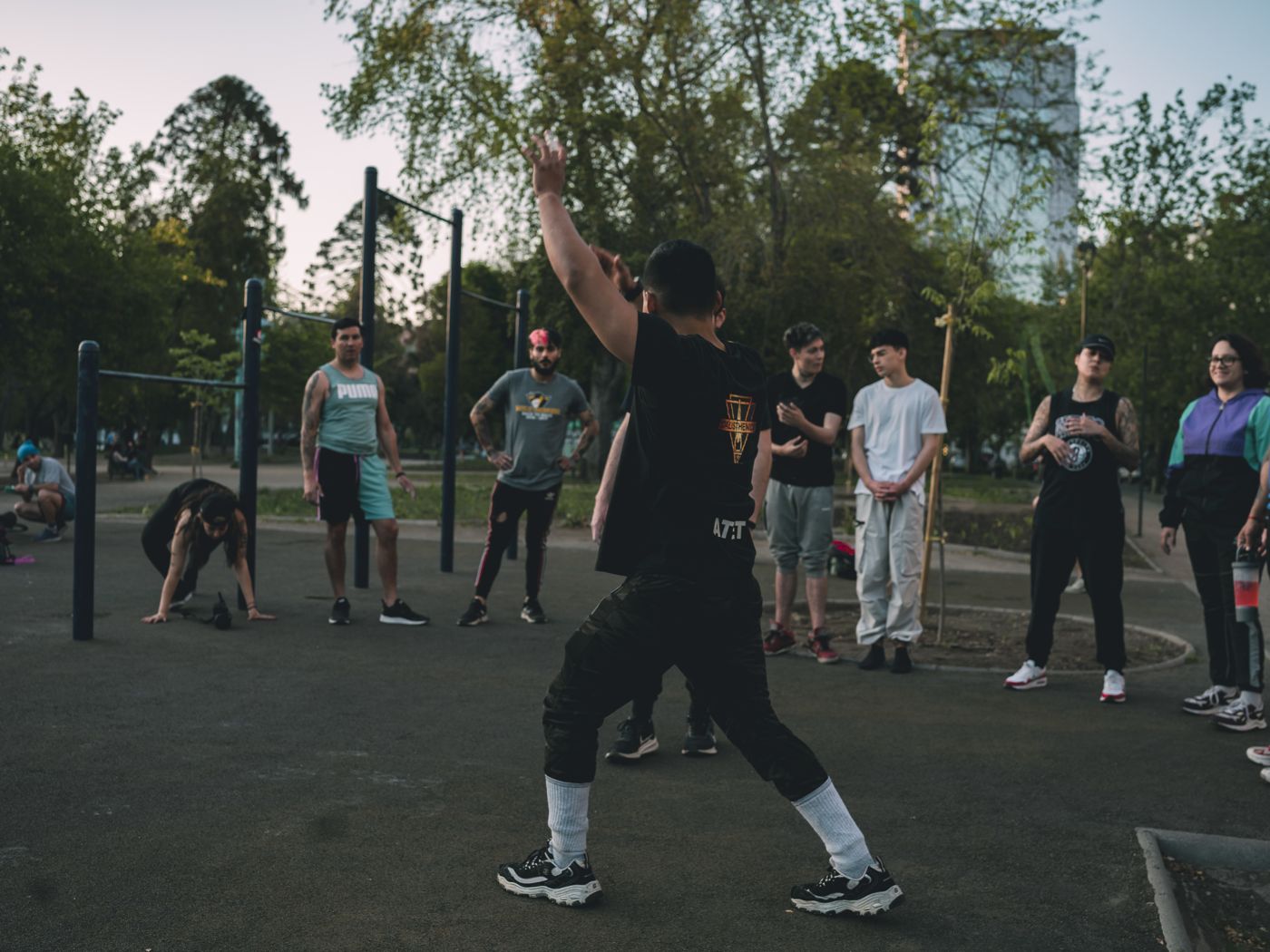 Elian De Vera dirigiendo una clase grupal de calistenia en el parque